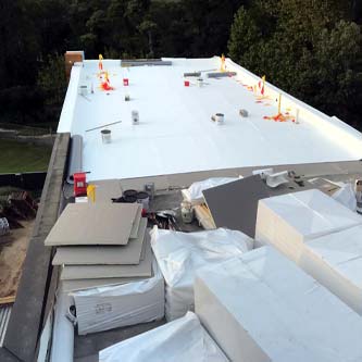 Commercial roof being replaced by team.